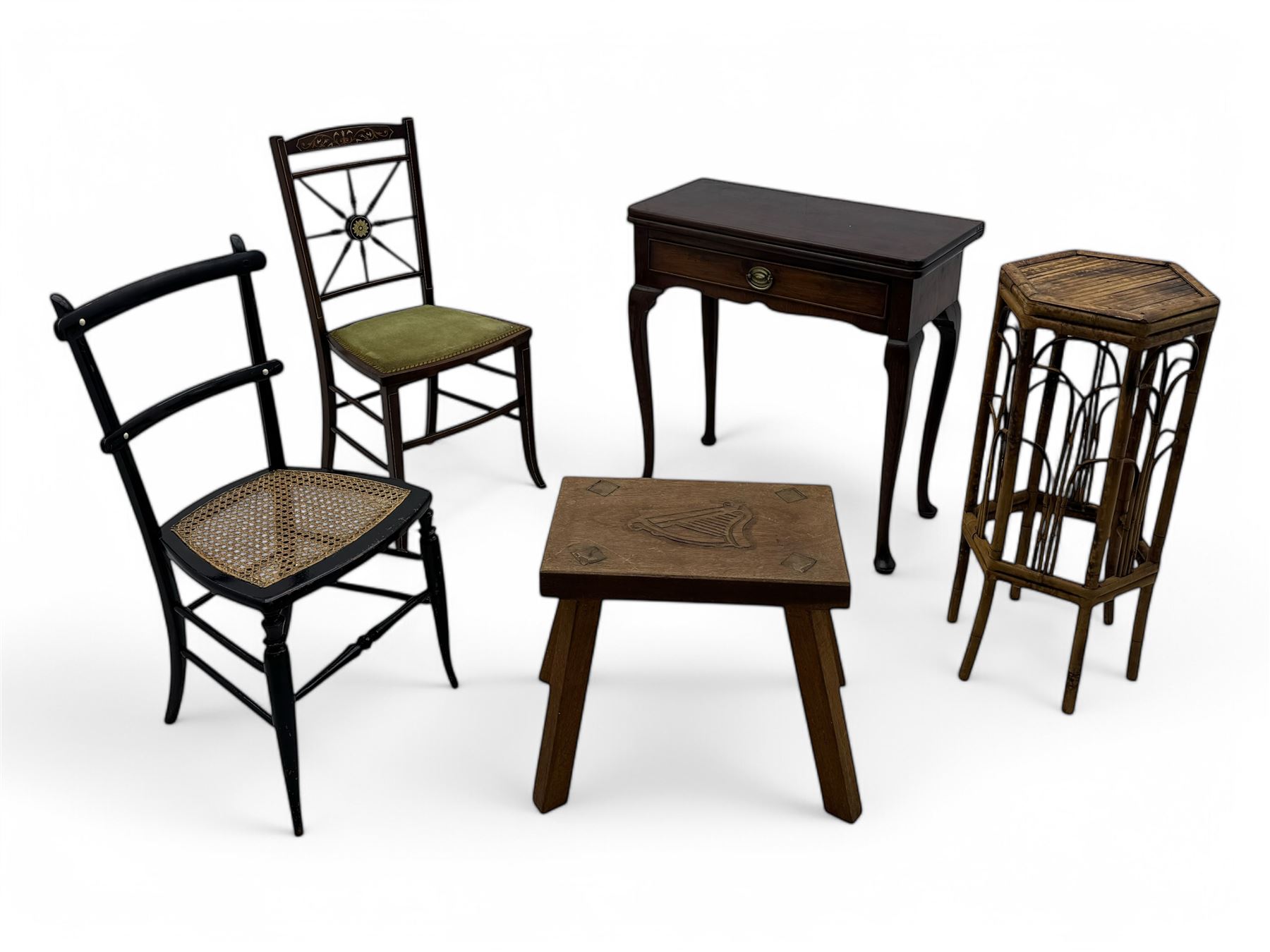 Late 19th century black-painted cane seat chair; early 20th century radial spindle-back chair with green upholstery; early 20th century mahogany single-drawer side table; mid-20th century carved wooden stool with harp motif; early 20th century hexagonal bamboo stand; two oval mirrors (7)