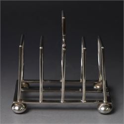 Victorian silver toast rack, with five angular bars and loop handle, upon four squat bun f...