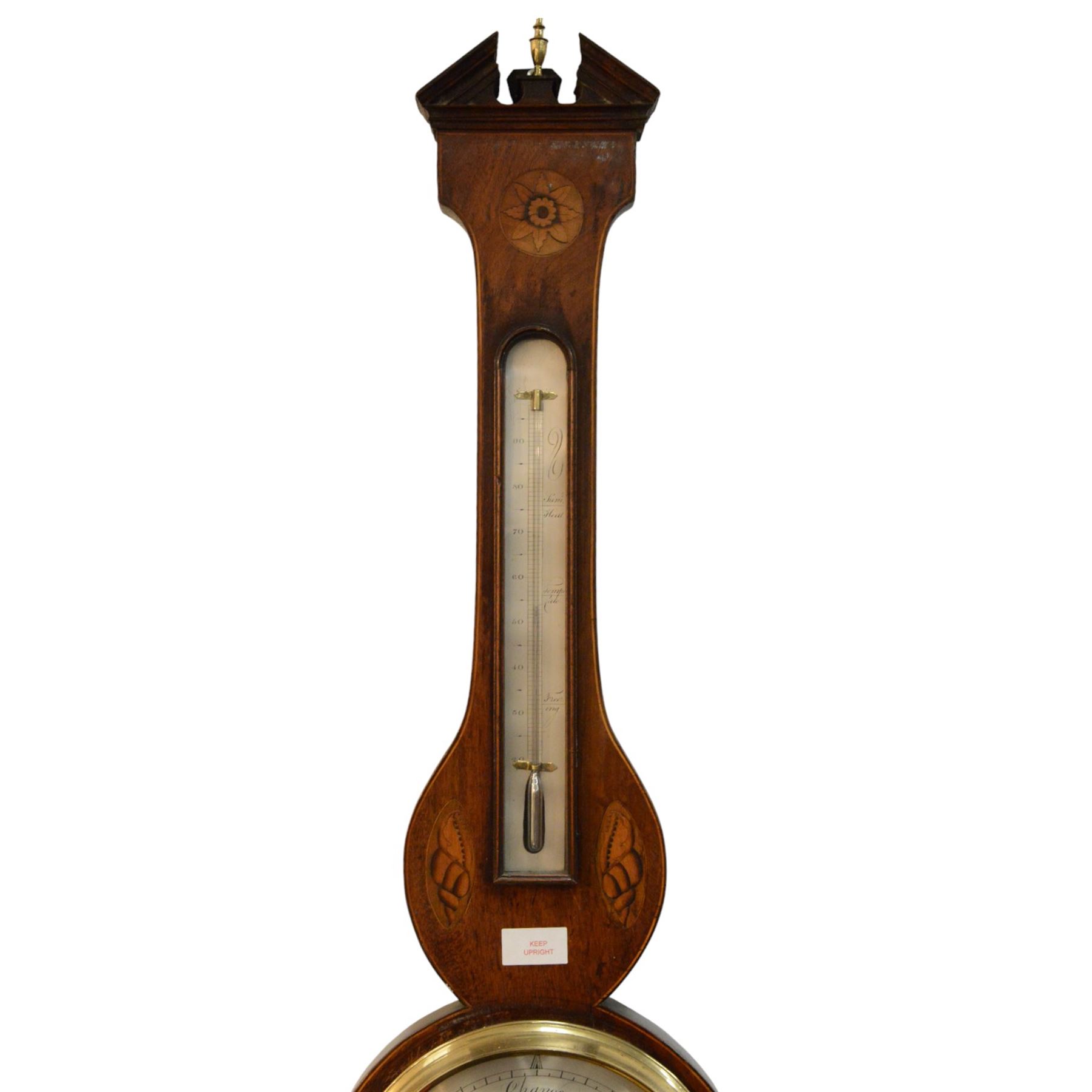 Early 19th century-Sheraton two instrument mercury barometer c1820, with a break arch top and round base, mahogany veneer with inlaid motifs and stringing to the edge, surface mounted mercury thermometer recording degrees Fahrenheit and an 8” silvered register with predictions and recording barometric air pressure from 28 to 31 inches, with a steel indicating hand and brass recording hand. Dial inscribed P. Nicho. 
Mercury present, syphon tube and pulleys intact.