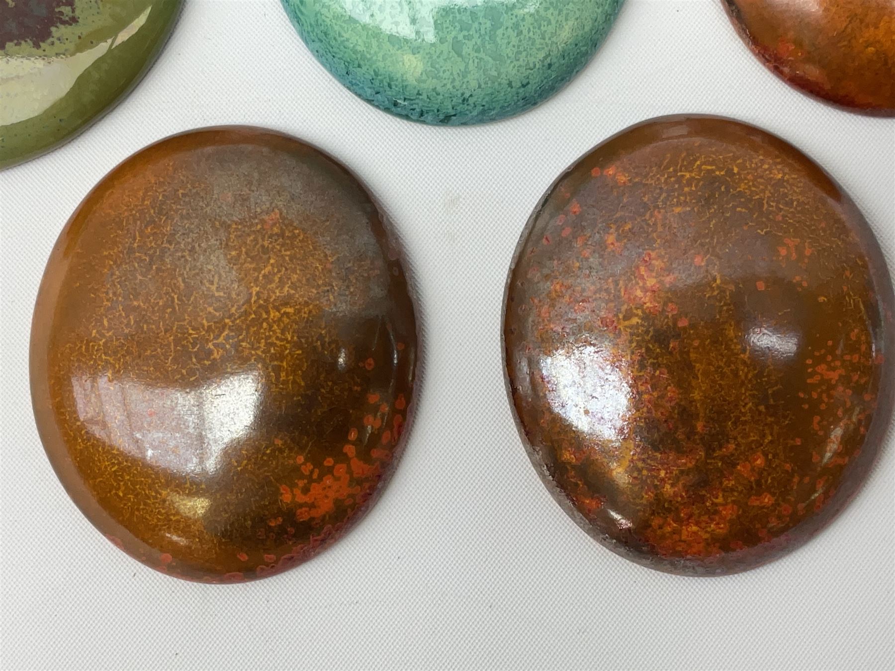 Henry George Murphy (1884-1939), collection of seven Arts & Crafts glazed ceramic roundels, of circular and oval form, five in tones of red and brown and two in tones of blue, turquoise and green in soufflé and high fired finishes, largest example D6.5cm