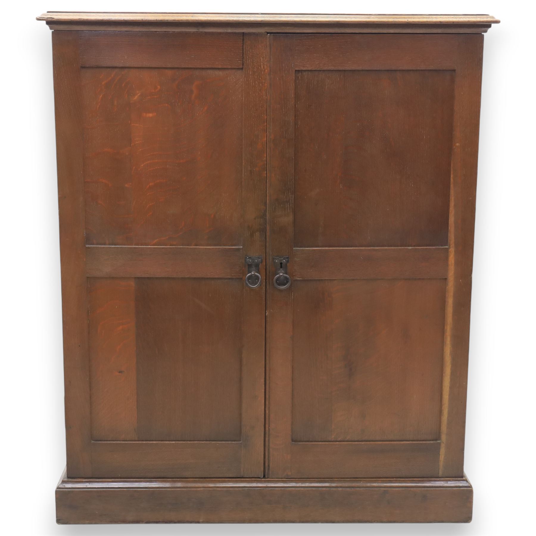 20th century oak Arts and Crafts fitted collector's cabinet, twin panelled doors with metal door pulls, enclosing a fitted interior, on a moulded plinth base