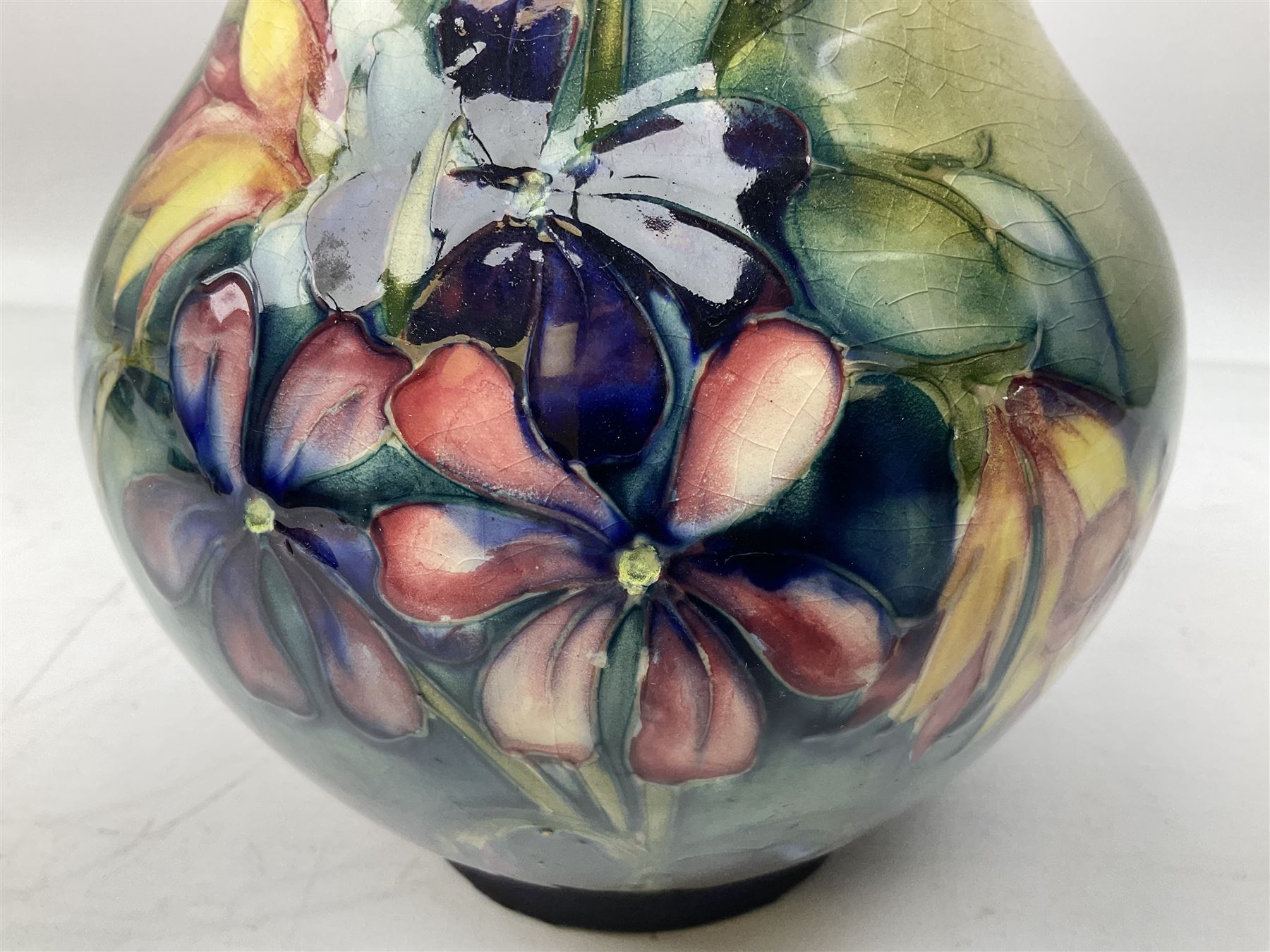 Moorcroft vase of baluster form decorated in the Spring Flowers pattern upon a merging green and blue ground, with impressed and painted marks beneath, H22.5cm