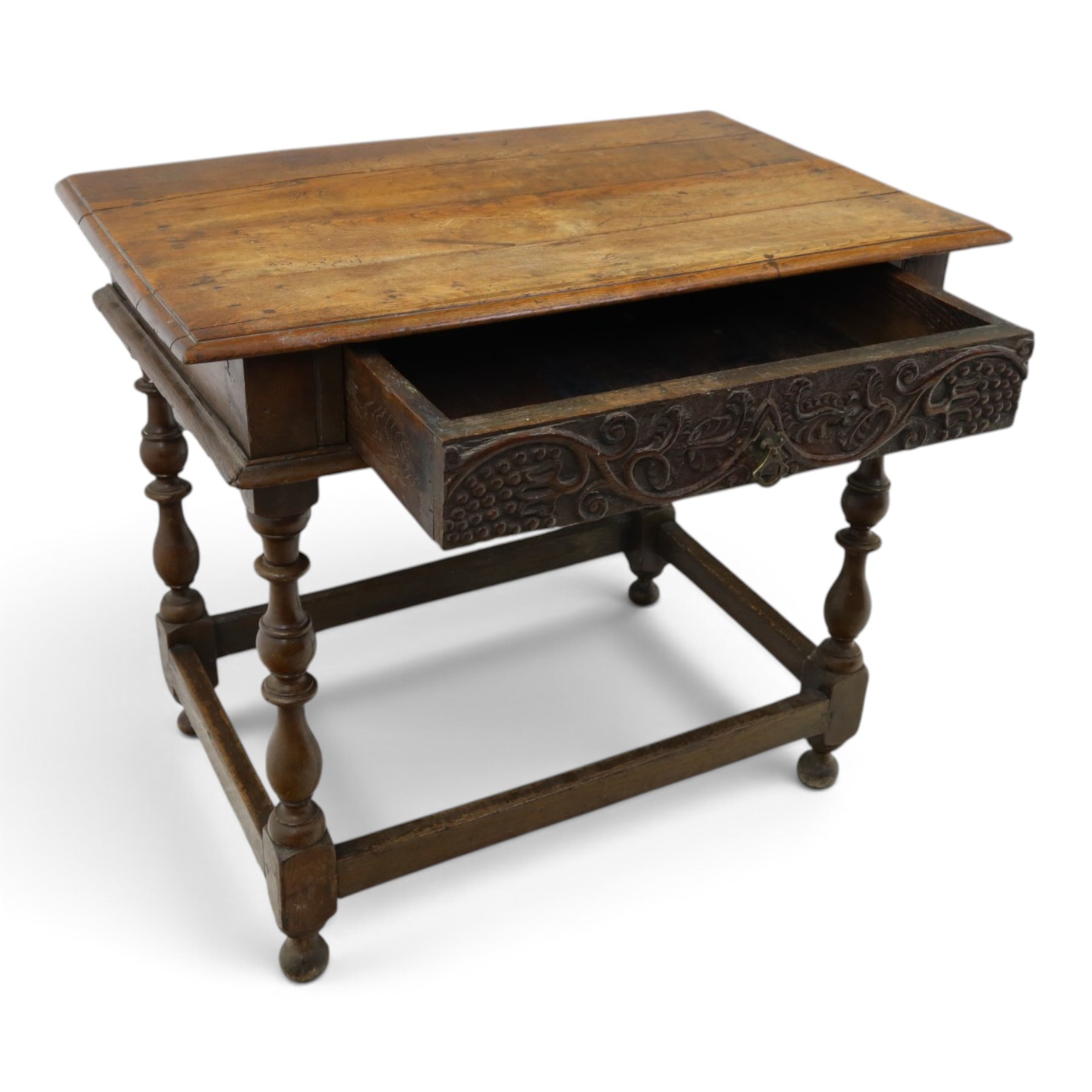 18th century oak lowboy, rectangular top with moulded edge, fitted with single frieze drawer carved with scrolling fruiting vines and stylised plant motifs, raised on bobbin-turned supports united by box stretcher 