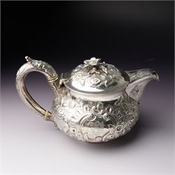 Matched three piece silver tea set comprising teapot of squat circular form London 1827,  milk jug of similar date and sugar bowl with Britannia standard marks, all with later embossed floral decoration and coat of arms, all marks rubbed