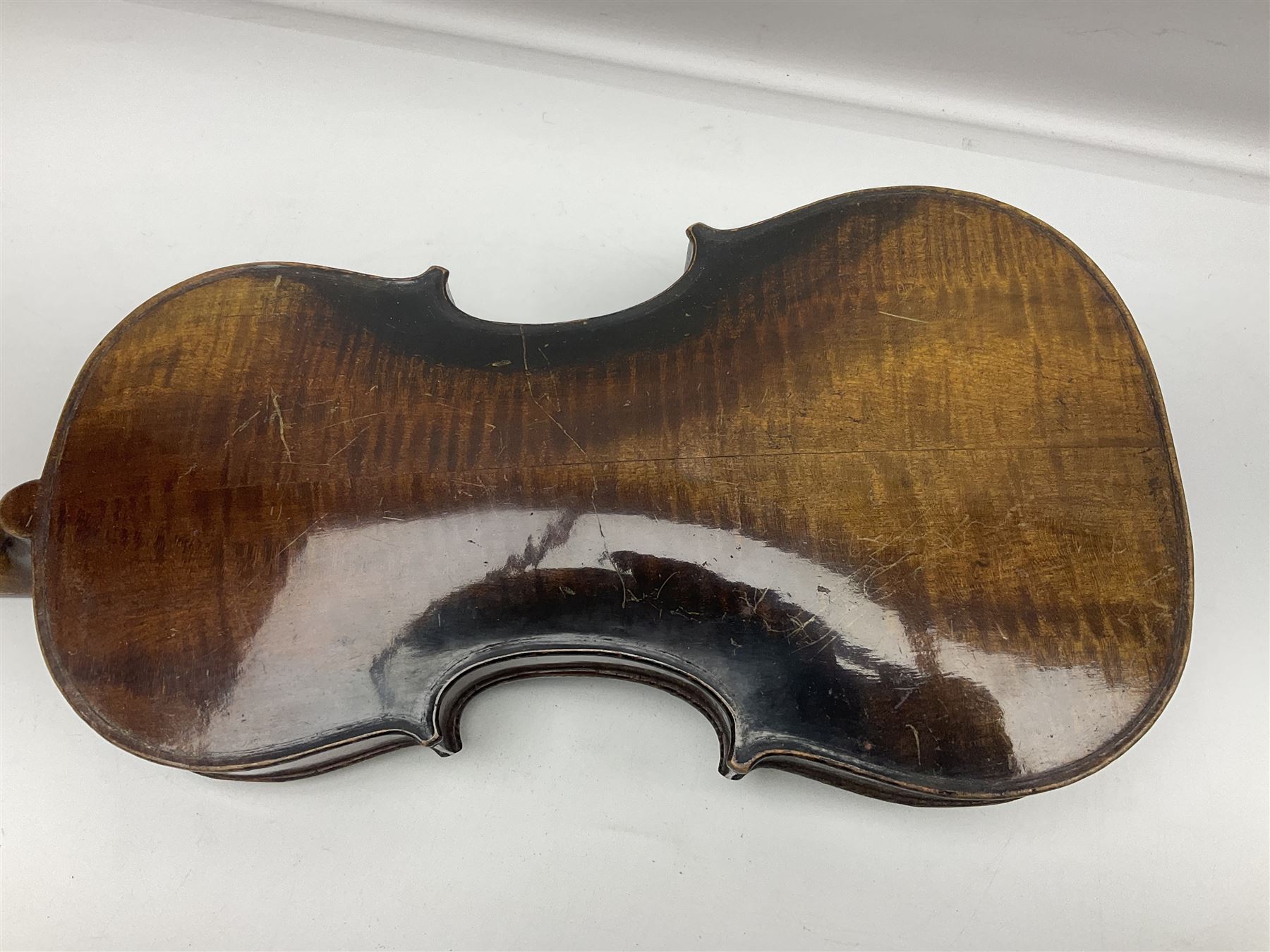 German violin c1890 with 36cm two-piece maple back and ribs and spruce top; bears label 'Antonius Stradivarius Cremona Faciebat Anno 1729' L59.5cm overall; in ebonised wooden 'coffin' case; and two German violins c1890 for completion - one bearing a Stradivarius label, the other a Ruggeri label; both in carrying cases (3)