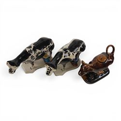 Three Staffordshire cow creamers, one with treacle glaze, the other two painted black and white with a seated figure of a milkmaid, H14cm