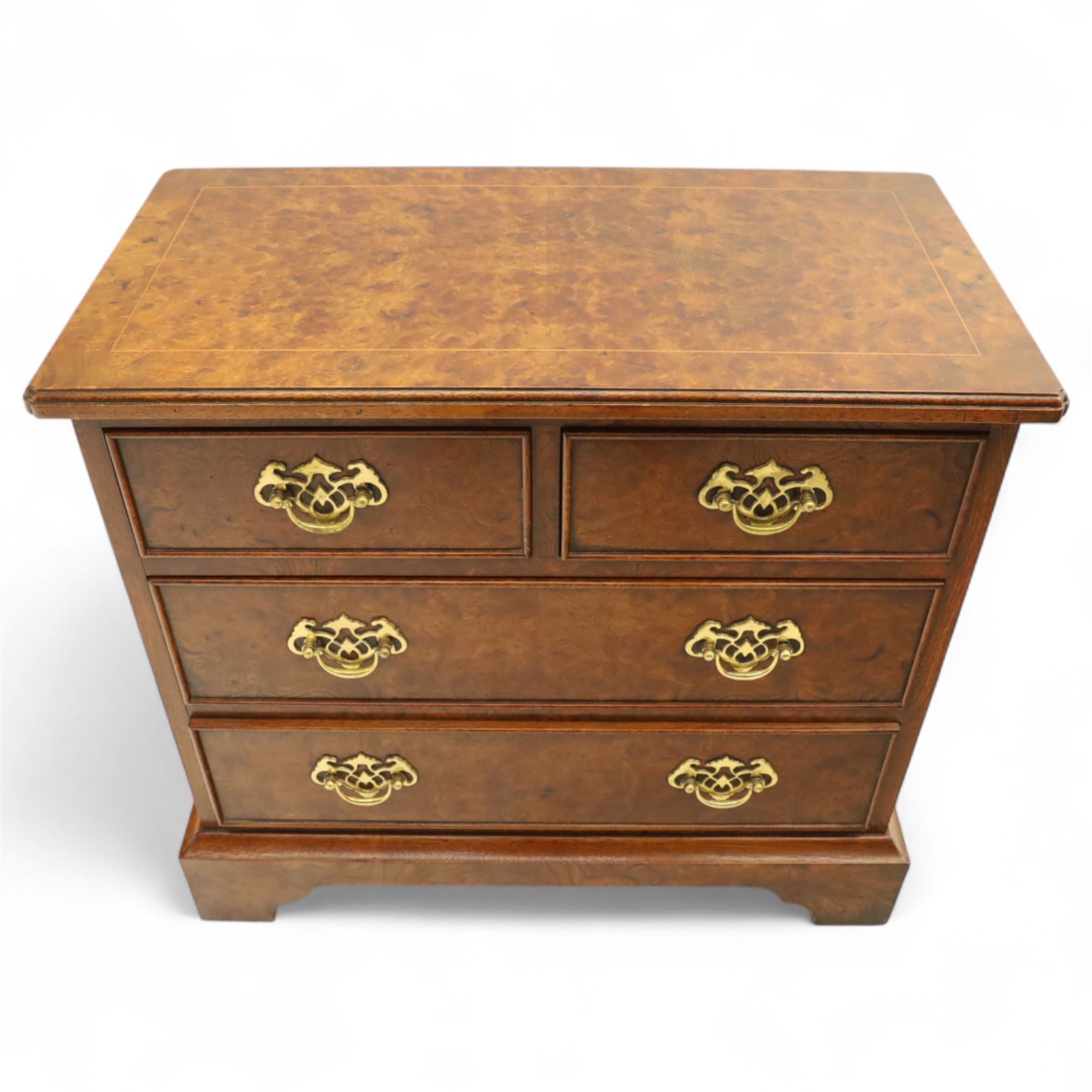 Late 20th century figured walnut miniature chest, the rectangular top with feather banded border over two short and two long drawers, fitted with brass batwing handles, upon moulded plinth base and four bracket feet, H60cm, w67cm, D36cm