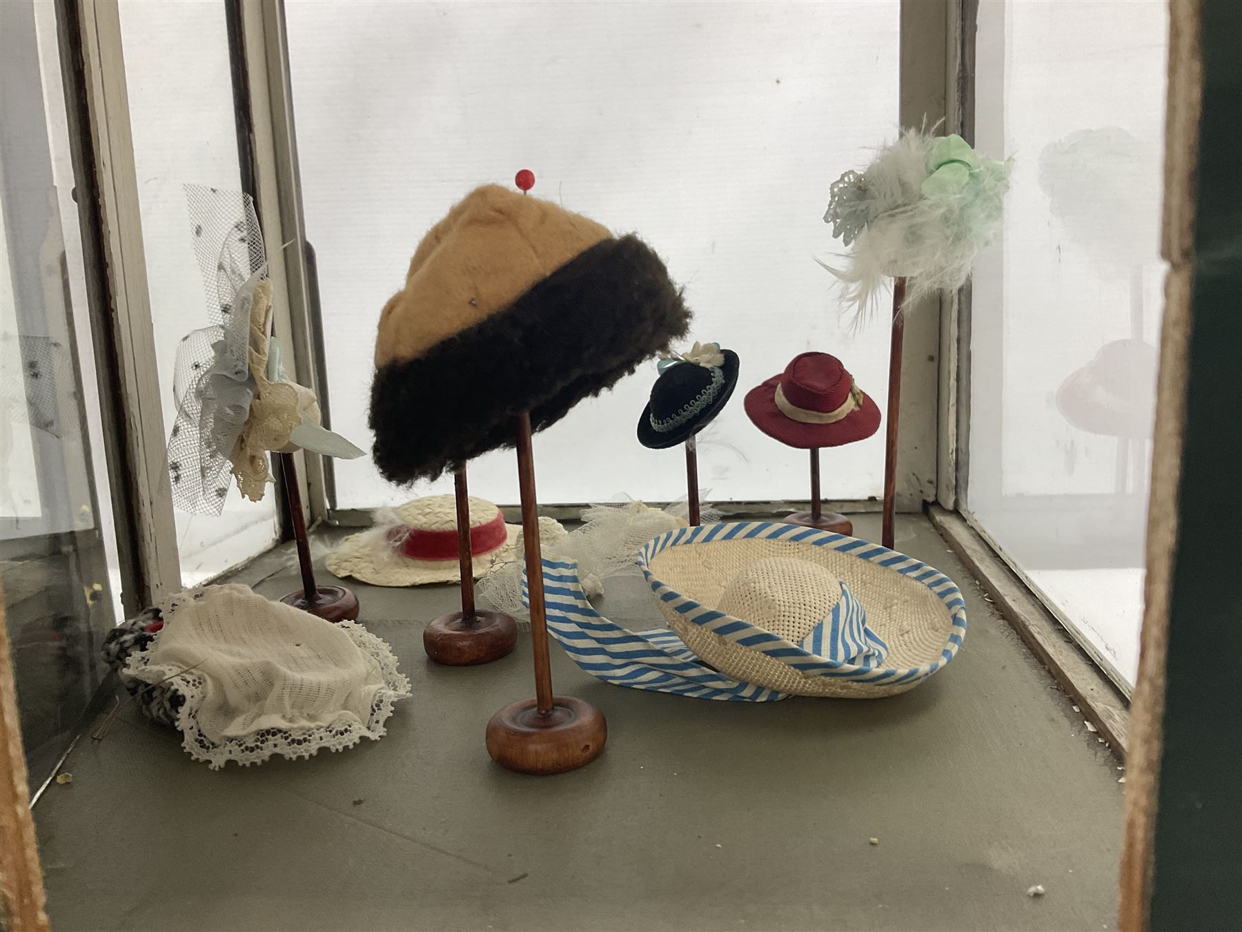 Early 20th century scratch-built wooden hat & gown shop diorama 'Joan', of double-fronted form glazed on three sides with brass and aluminium mounts, rear access apertures and storage under L63cm H45cm D31cm; with small collection of dresses and hats on display stands