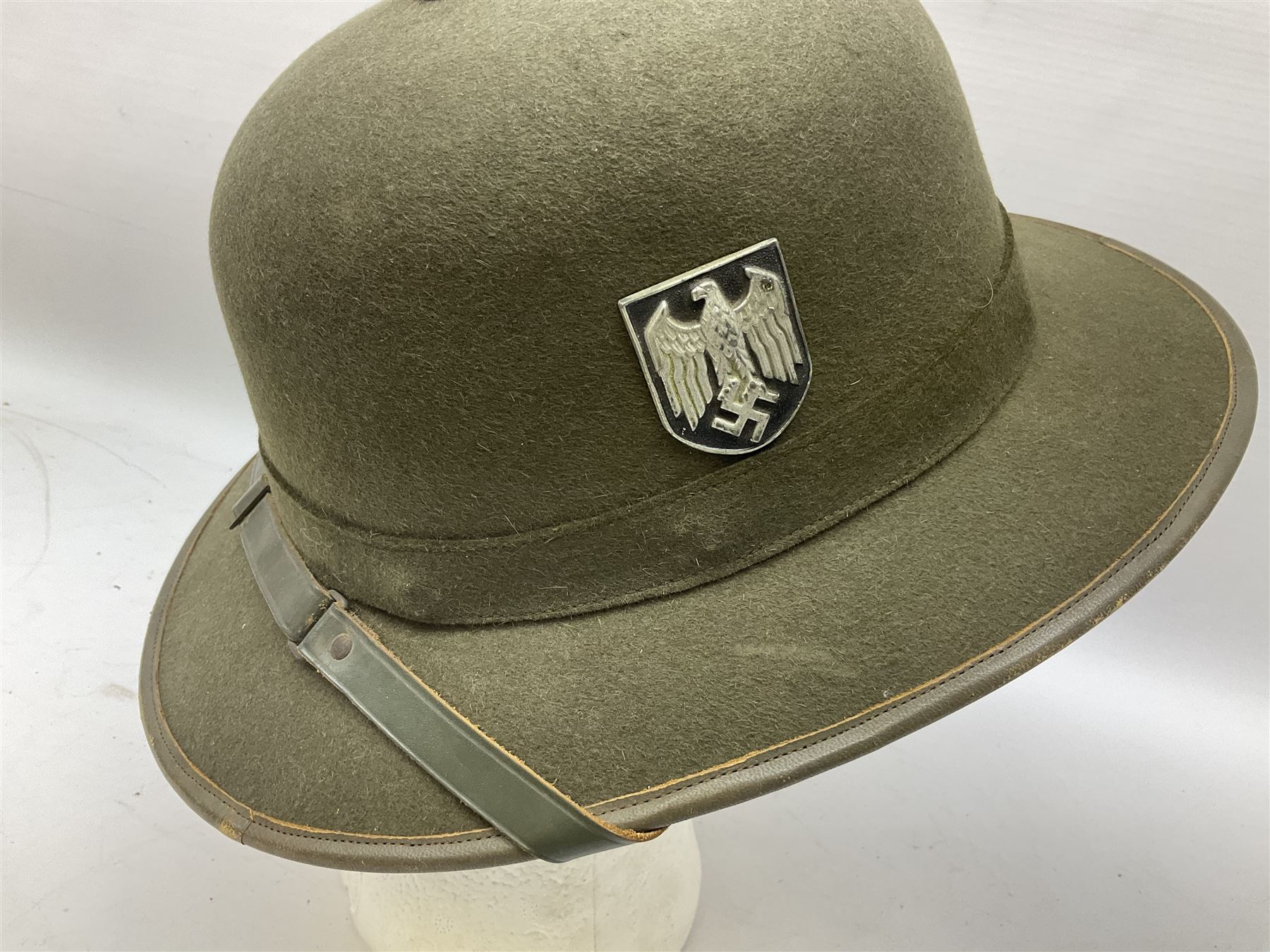Five reproduction German WW2 hats comprising Wehrmacht olive tropical helmet, Heer officer's peaked cap, two M43 caps and Field side cap (5)