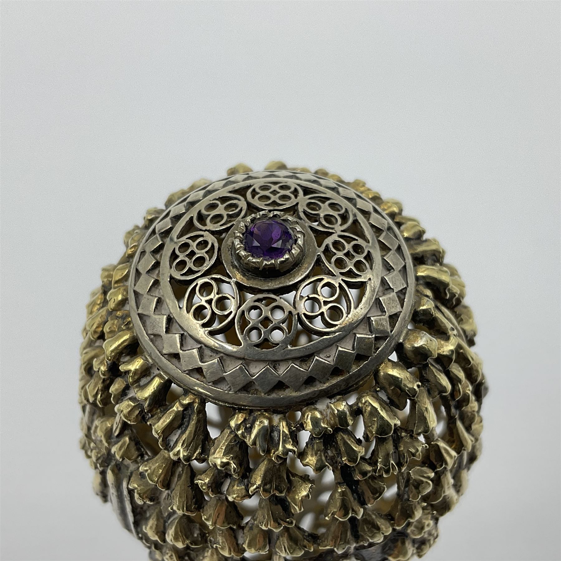 Modern silver limited edition Easter egg, no. 70/500, the gilt openwork body decorated with cascading bluebells and hinged cover with pierced circular panel set with a single faceted purple stone, opening to reveal a gilt interior, upon silver stand with three scrolling pad feet, each hallmarked St James House Company, London 1981, height including stand 8cm