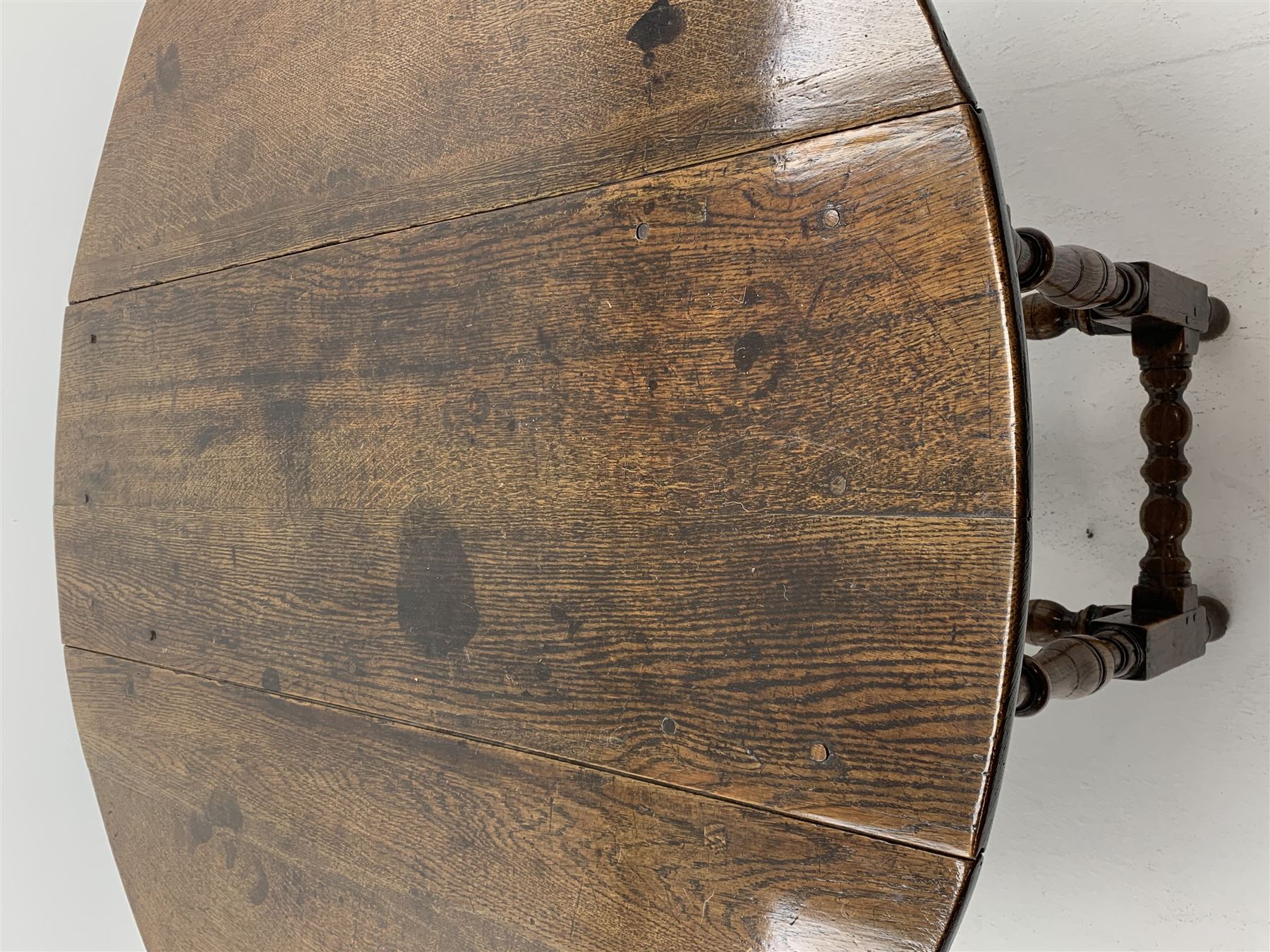 Late 17th century William & Mary oak drop leaf dining table, oval drop leaf top, single drawer to one end, gate action base, turned supports joined by bobbin turned stretchers, 121cm x 135cm, H75cm (open)