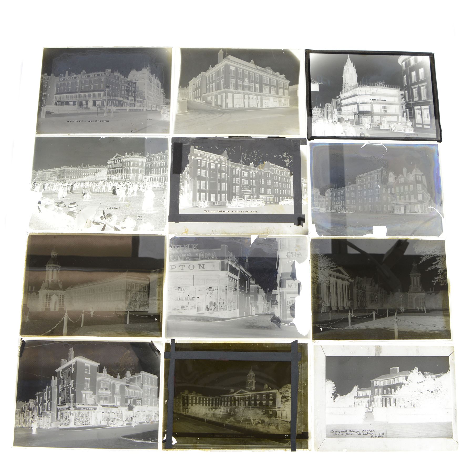 Collection of eleven plate glass negatives, depicting buildings, within a metal case 