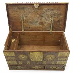 Early 20th century brass-mounted hardwood chest, the hinged top and front richly decorated with applied and studded brass panels and pierced lock escutcheon, revealing a candle box, reinforced with brass corner mounts