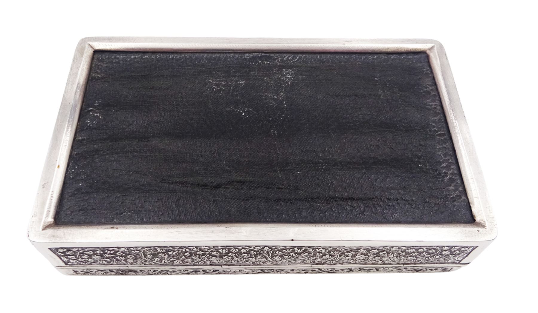 Indian silver cigarette box, of rectangular form with chassed and embossed foliate decoration and vacant rectangular panel to hinged cover, opening to reveal softwood lined interior with division, H3.3cm W14.3cm D8.5cm, stamped Silver VR Co with elephant mark