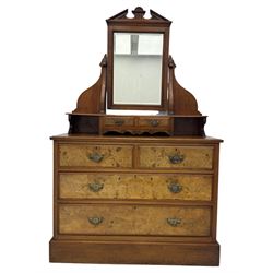 Victorian walnut bedroom suite - wardrobe, dressing chest and bedside cupboard, comprising a full-length wardrobe with broken pediment and central mirrored door, large lower drawer, a matching dressing table with bevelled swing mirror over two trinket drawers and two short drawers over two long drawers, and a single-door bedside cupboard, all with moulded edges, decorative panel work and shaped aprons