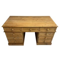Pine twin pedestal desk, fitted with nine drawers, on plinth base