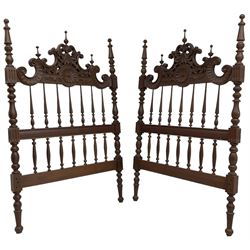 Pair of Spanish carved hardwood headboards, the pediment carved and pierced with shell C-scrolls and carved foliage, turned spindle back, on turned supports 