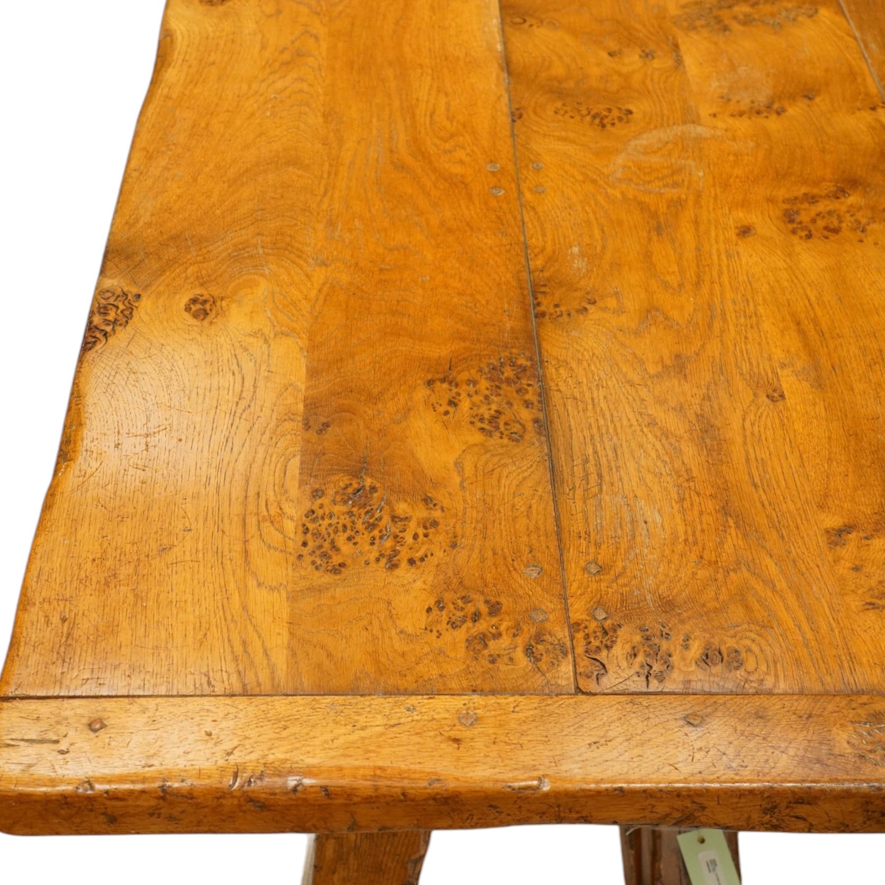 Quality golden figured and burr oak farmhouse refectory dining table, the rectangular plank top with cleated ends, raised on square supports united by arched and H-stretcher trestle base