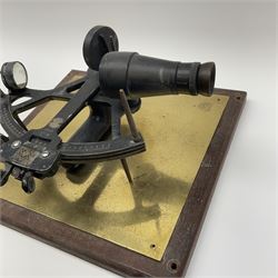 Henry Hughes & Son 'Husun' black finished brass sextant marked H (broad arrow) O No.336; mounted on a mahogany and brassed backboard for wall display 33 x 31cm