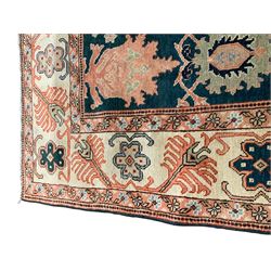 Persian emerald green ground rug, the field decorated with large stylised plant motifs, ivory ground border with repeating leaf motifs, the guards decorated with trailing branch and flowerhead motifs