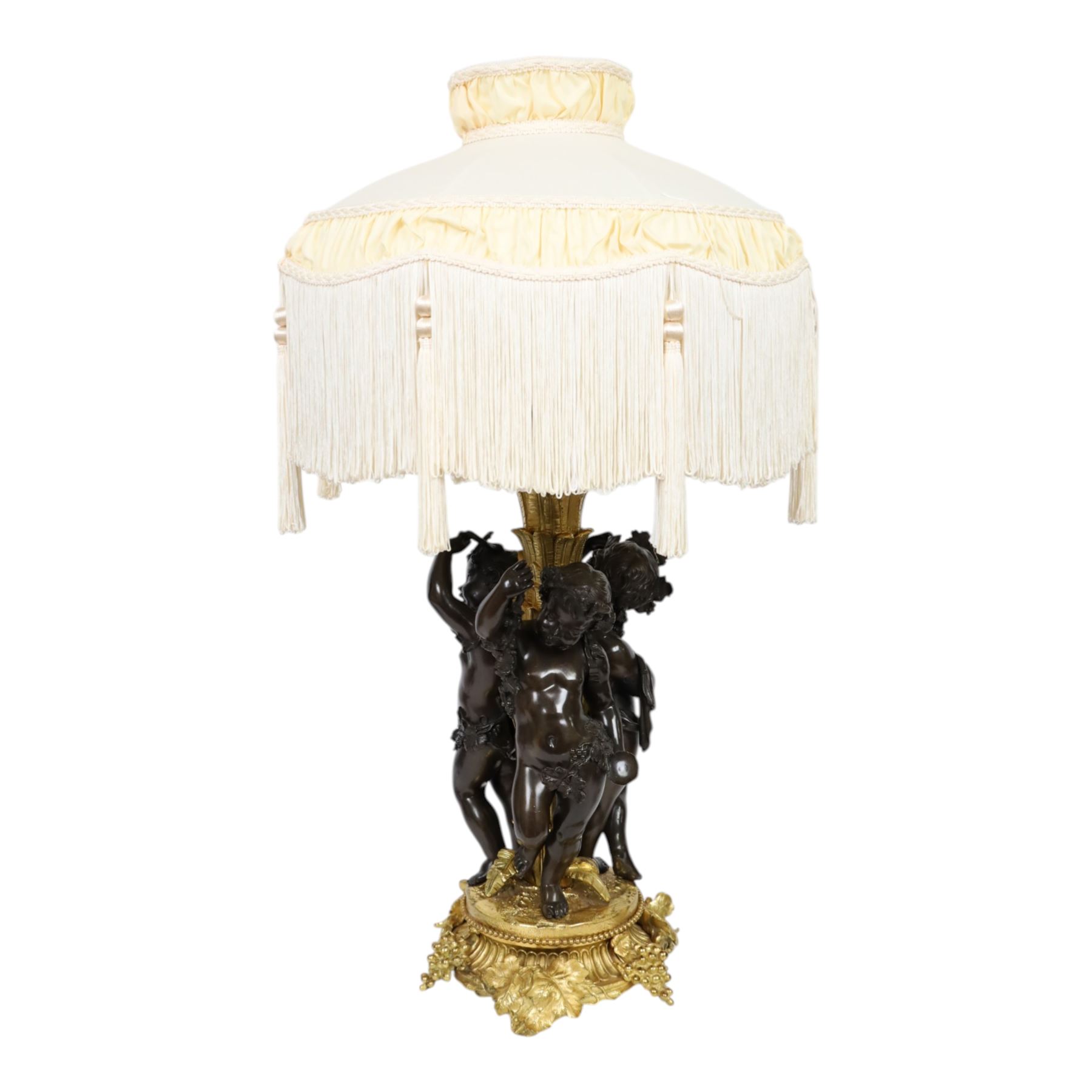 Louis XVI style gilt table lamp, the central column decorated with acanthus leaves, surrounded with three putti with vine leaf crowns, upon a circular base adorned with grape and vines, with shade, H64cm