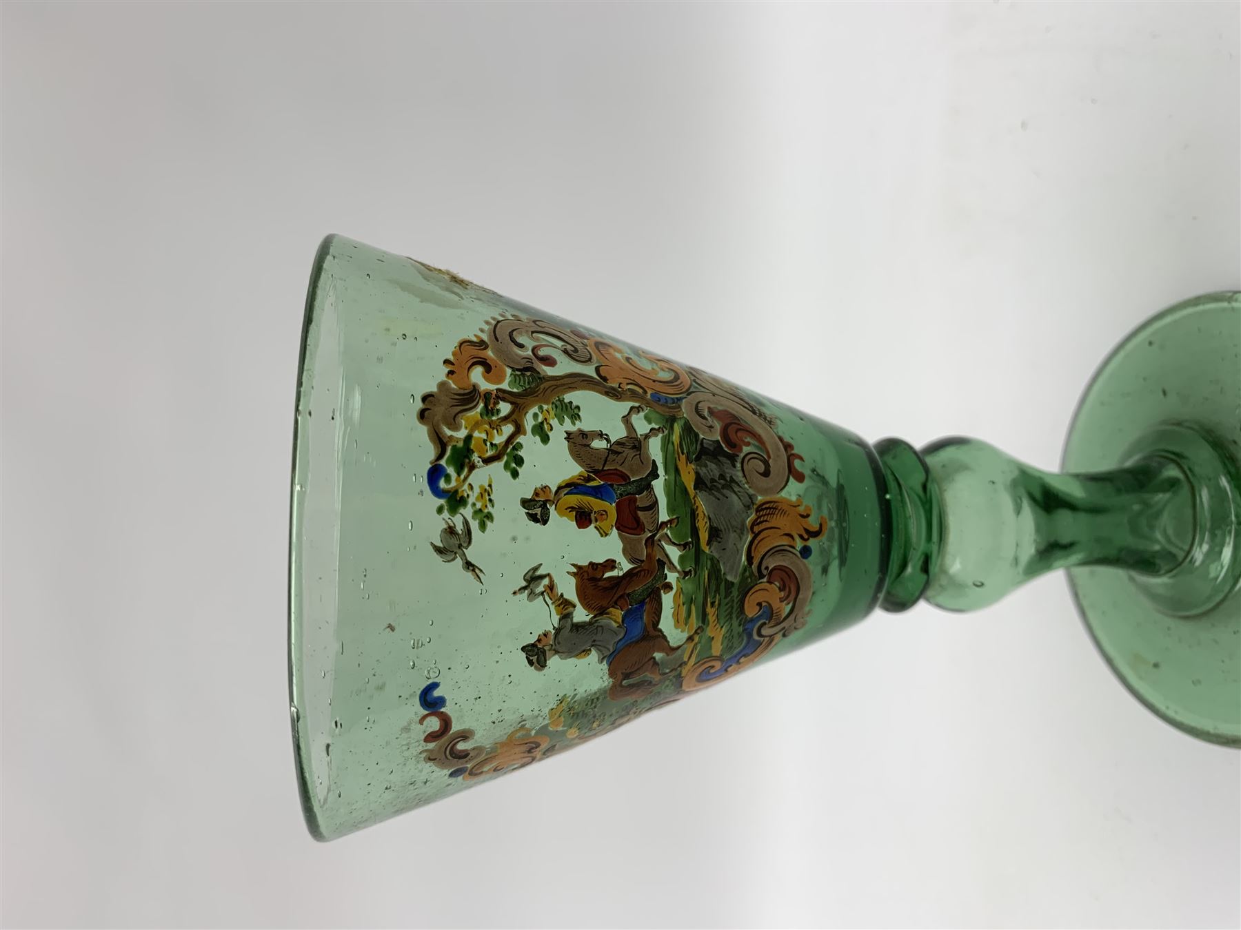 19th century bohemian green glass wine glass, the funnel bowl decorated in enamells with a Historismus hunting scene in the manner of Egermann & Lobmeyr, upon a baluster stem and circular foot, H14.5cm