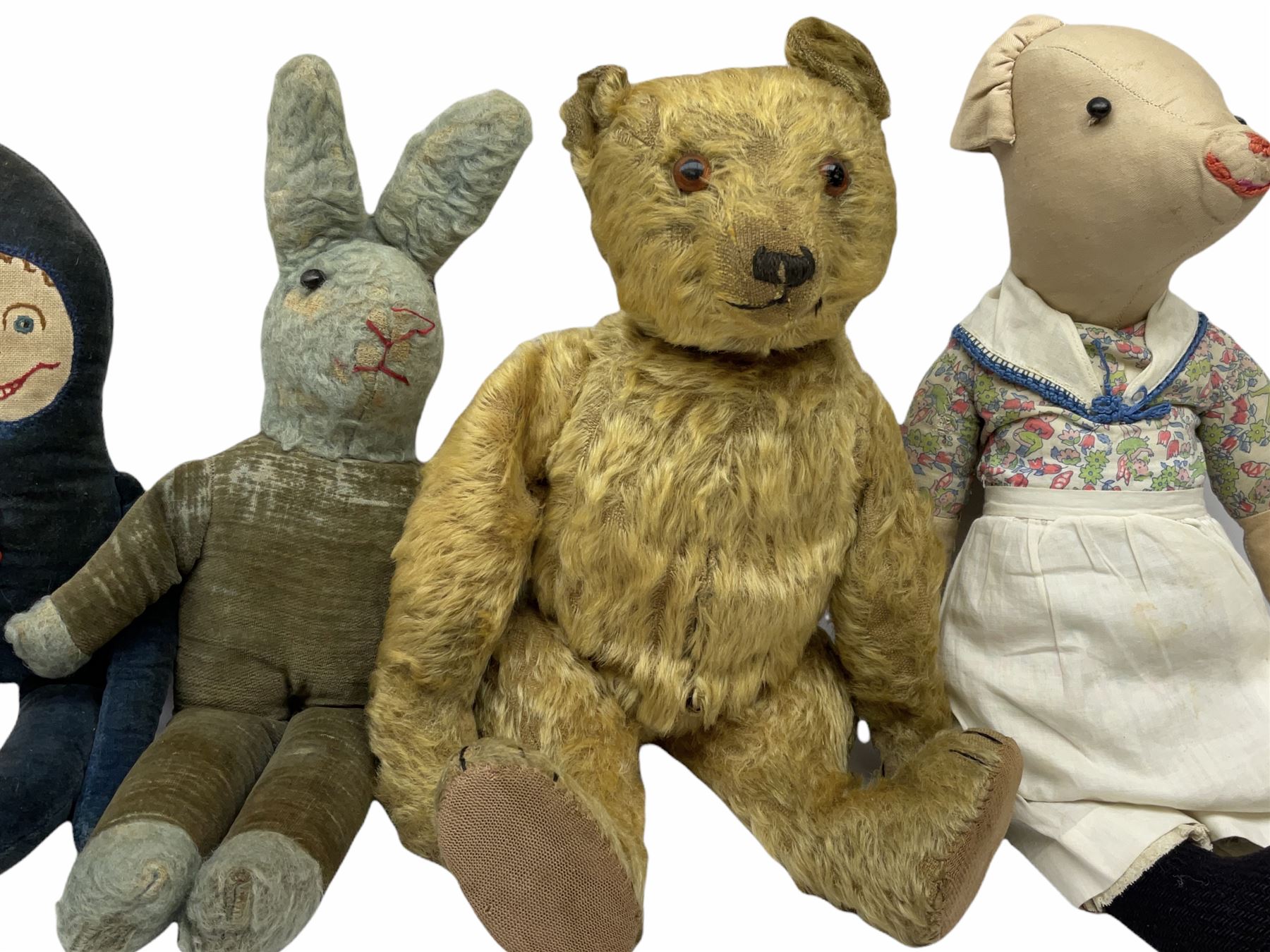 1950's teddy bear with jointed limbs, revolving head, wood filled body, stitched nose and mouth, applied glass eyes and foot pads, together with a quantity of handmade soft toy rabbits and penguins. 