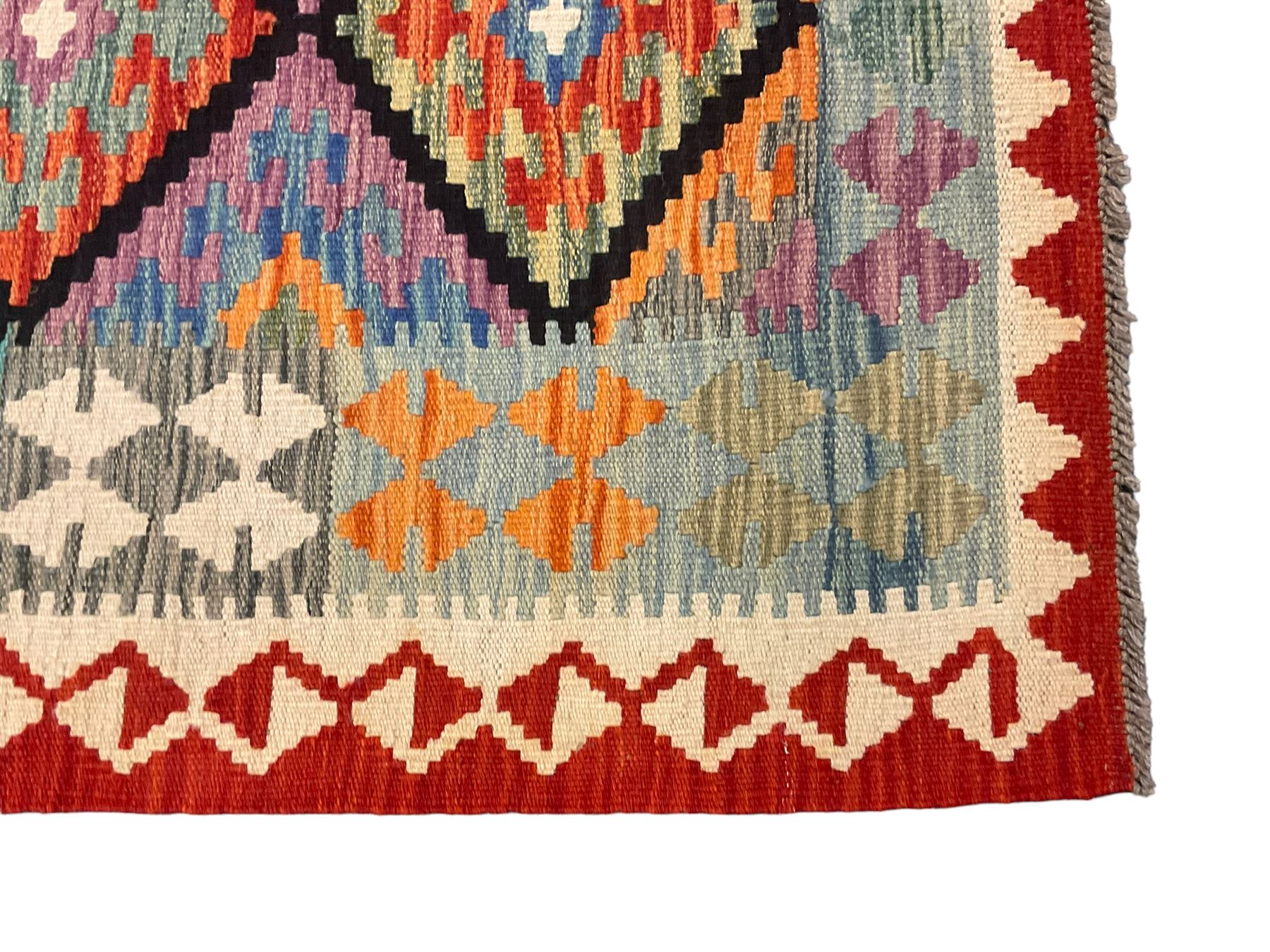 Anatolian Turkish Kilim multi-colour rug, decorated with all over lozenges in contrasting colours with dark indigo outline, the multi-band ivory and red border with repeating geometric shapes and small lozenges or diamonds