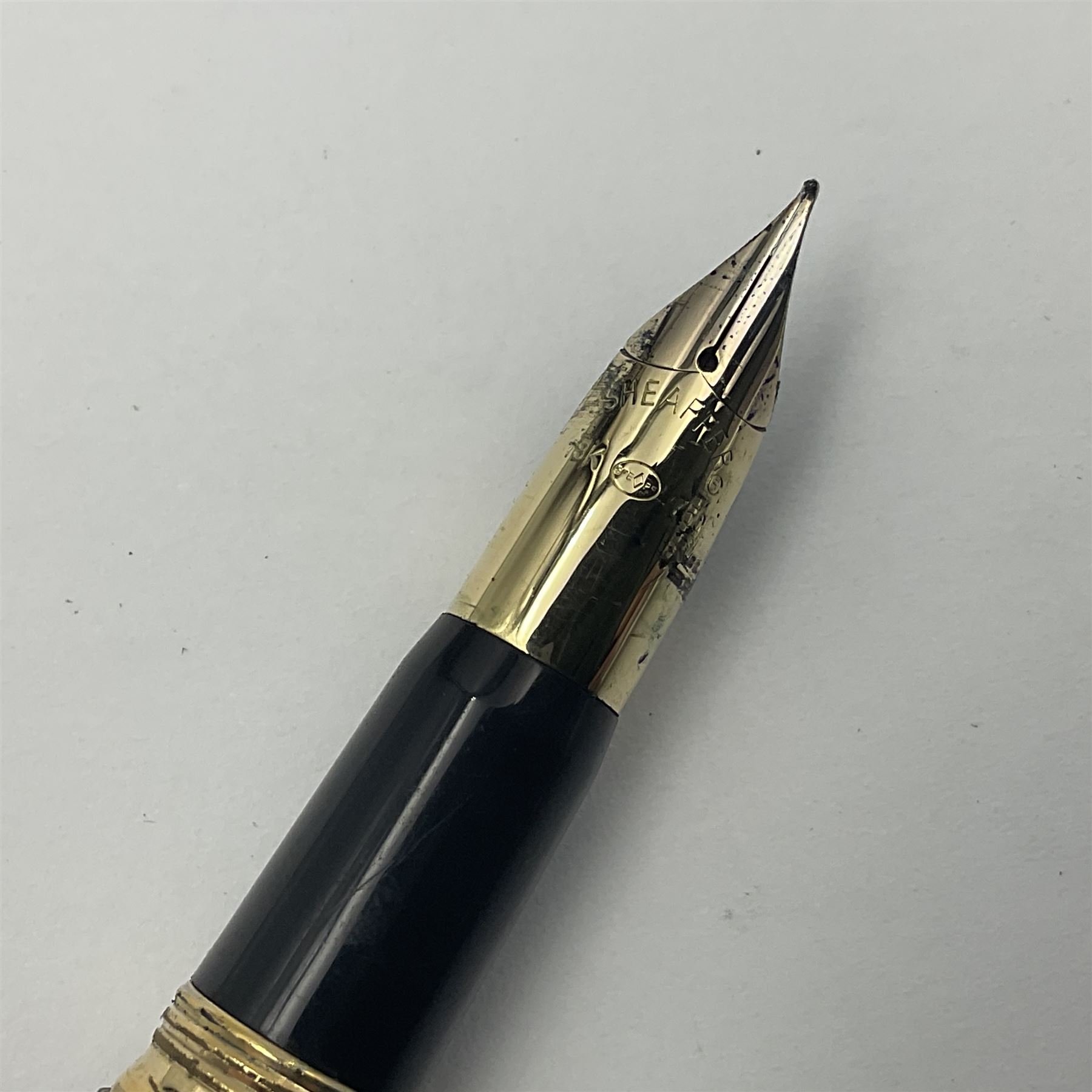 Sheaffer Crest fountain pen, the black barrel with gold plated cap and 18K nib, together with a matching ballpoint pen and further fountain pen, longest L14cm (3)