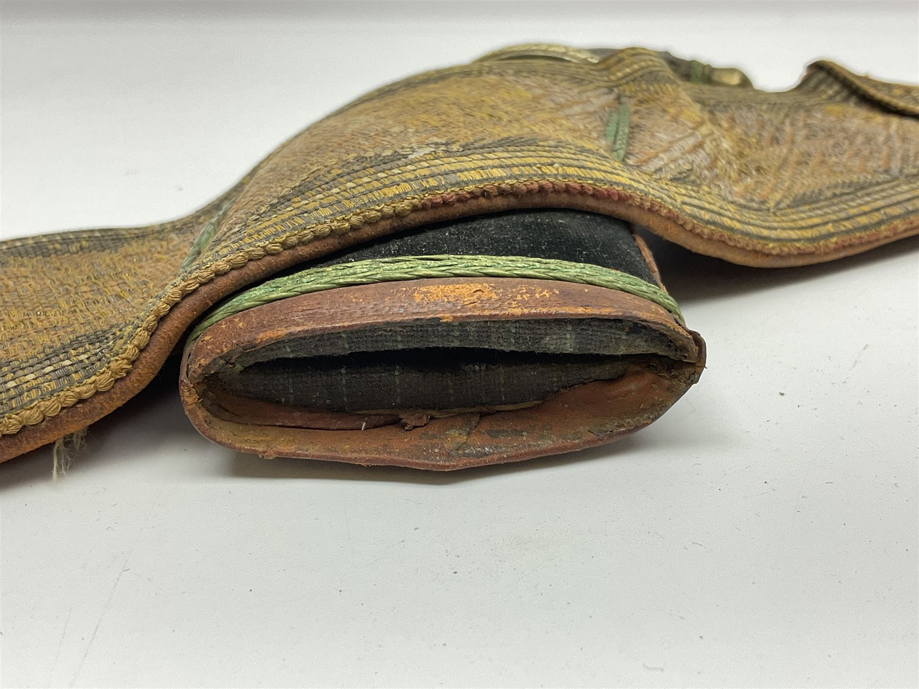 Late 19th century Yemeni Tuza jambiya as worn by religious elite, the 20.5cm curving blade with raised medial ridge, the horn hilt with pique style studwork, in a leather wrapped wooden scabbard with pierced metal mount and leather belt applied with embroidered 'gold' and 'silver' thread work panel; dagger L36cm overall, belt L84cm