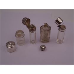Four silver mounted glass scent bottles, including a Victorian cut glass example with embossed silver cover, and three cylindrical plain glass examples, on with engine turned decoration, three with glass stoppers, together with a pair of silver salts and spoons, all hallmarked, tallest H8cm