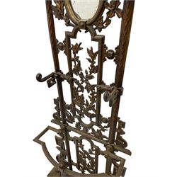 19th century cast iron hallway hat and coat stand, the arched frame decorated with overlapping foliage, central oval mirror surrounded by trailing oak leaves and acorns, with extending umbrella and stick stand, the curved plinth base decorated with acanthus leaves, with impressed and mounted R.d. lozenges