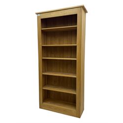 Contemporary light oak open bookcase, rectangular form with projecting top, fitted with five adjustable shelves, on a straight plinth base