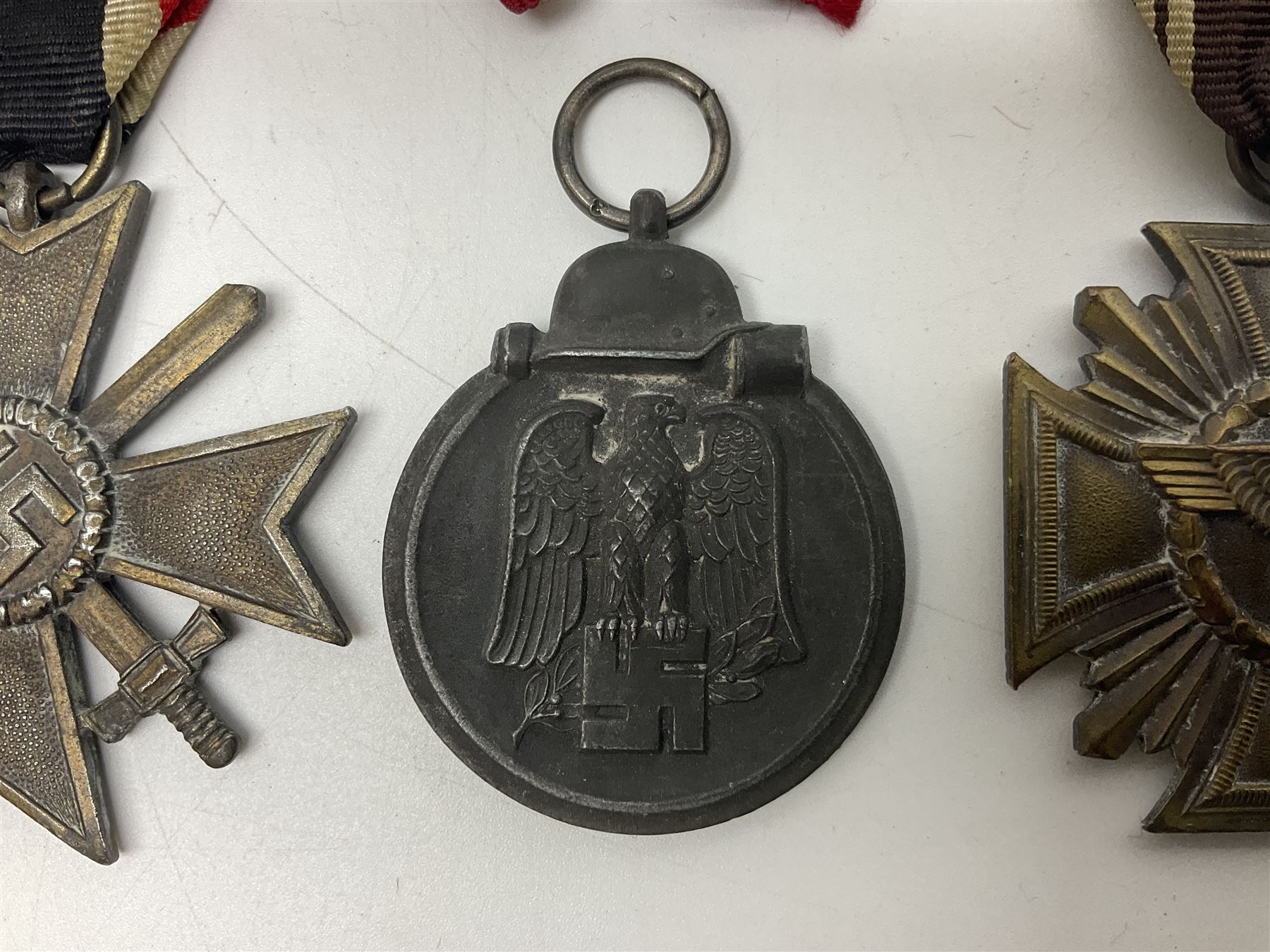 WW2 German Eastern Front Medal awarded to those who served on the German Eastern/Russian Front during the Winter Campaign period of 15th November 1941 to 15th April 1942 with original ribbon; German War Merit Cross with swords; and NSDAP Long Service Award (3)