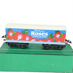 Three 0 gauge coaches, comprising an ACE Trains tin-printed All Third coach in LMS maroon livery, an ACE Trains tin-printed EMU MET 1st coach and a 'neverwazza' goods wagon, painted in Cadbury's Roses livery