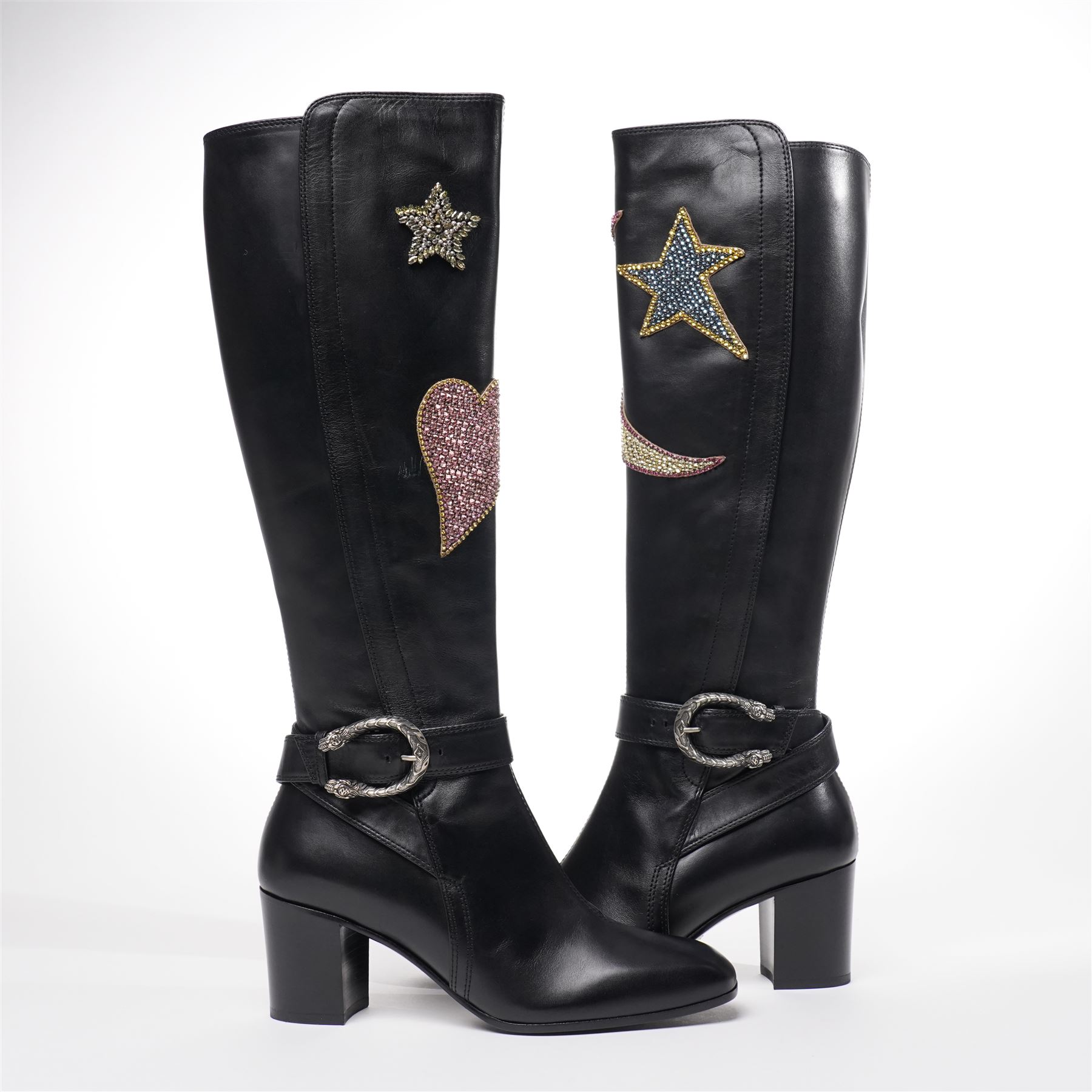 Gucci - pair of Dionysus buckled knee-high leather boots, in black with block heels, applied with rhinestone star, moon and heart applique motifs, with the signature silver tone tiger head buckle fastening and full length zip, size 38, total boot height 48cm, unused with original box and dust bags