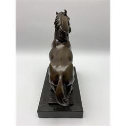 Bronze figure modelled as a prancing horse, upon a naturalistically modelled rectangular base, and black marble plinth, H34.5cm, L31cm