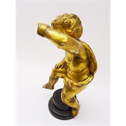 Early 18th century giltwood and gesso figure, carved in the form of a putto, upon later ebonised circular stepped base, H30cm