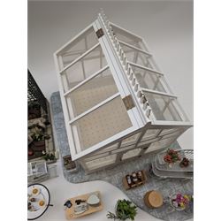 1:12 scale dolls house conservatory and garden accessories, including white wooden glazed conservatory on a stone effect base, black and white metal garden seating, barbecue, plant shelves, parasol, barbeque accessories, large planters, rabbit hutch, animals, chimenea, etc