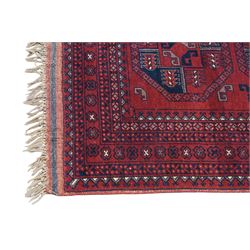 Afghan red ground Bokhara rug, the field decorated with two rows of large Gul motifs, within geometric pattern borders 