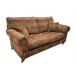 Duresta - 'Beaminster' grande two-seat sofa, traditional shape with rolled arms, upholstered in 'Althorp' russet and stone floral pattern fabric, on turned feet with brass castors
