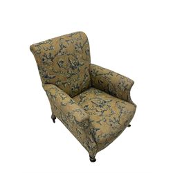 Victorian walnut armchair, upholstered in floral scroll patterned fabric, on turned front supports with brass castors