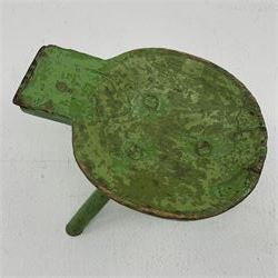 18th/19th century vernacular primitive green painted stool with dished seat fitted with metal scraper to one end, on three splayed legs, L46cm, H34cm