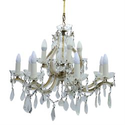 20th century Maria Theresa style twelve branch chandelier, gilt metal frame with scrolling arms clad in moulded glass, the central baluster stem issuing twelve candle sconces with glass drip pans, hung with faceted pendants and swags of cut glass beads 
