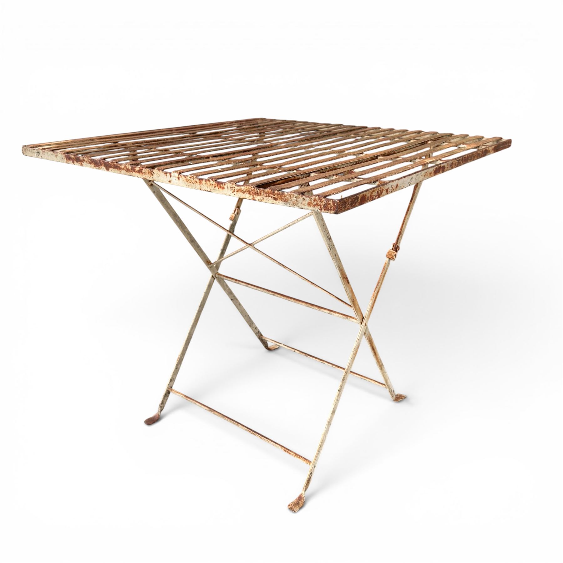 Pair of French 1920's wrought metal folding bistro café tables, the strapwork top over a folding X-frame base, in rustic white painted finish
