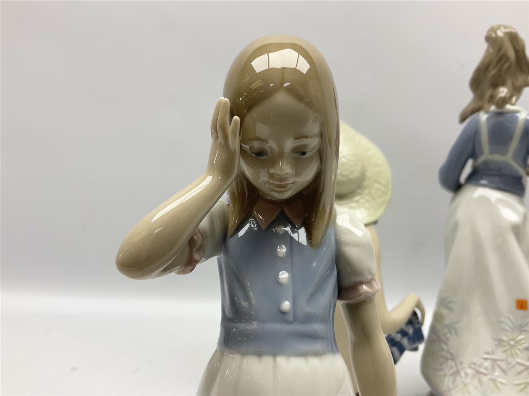 Three Lladro figures, comprising Modern Mother no 5873, Dropping the Flowers no 1285 and On the Beach no 1481, all with original boxes, largest example H30cm