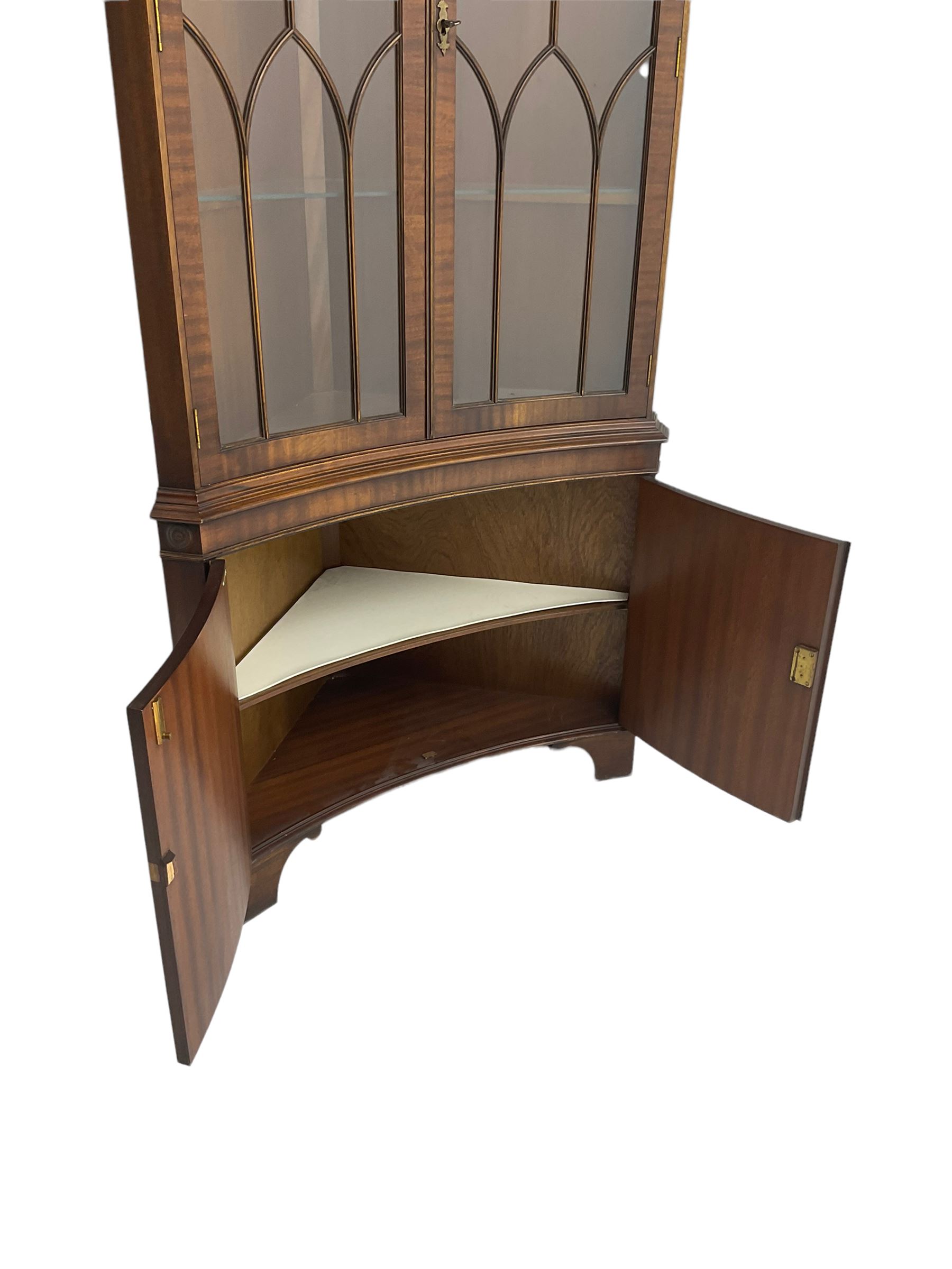 Bevan Funnell Reprodux - mahogany concave corner display cabinet, the moulded and dentil cornice over two astragal glazed doors, double cupboard below enclosed by figured doors, on bracket feet