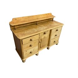 Victorian pine breakfront sideboard or dresser, raised back with shelf, fitted with central drawer and cupboard flanked by six graduating drawers, raised on bun feet