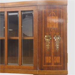 Continental Art Nouveau cocktail cabinet, the stepped cornice over a glazed upper section with panelled doors, enclosing fitted shelf, the central section with mirrored back and green baize serving surface flanked by ebonised and gilt detailed pilasters, the base fitted with cupboard doors inlaid with stylised foliate and geometric motifs, on a plinth base