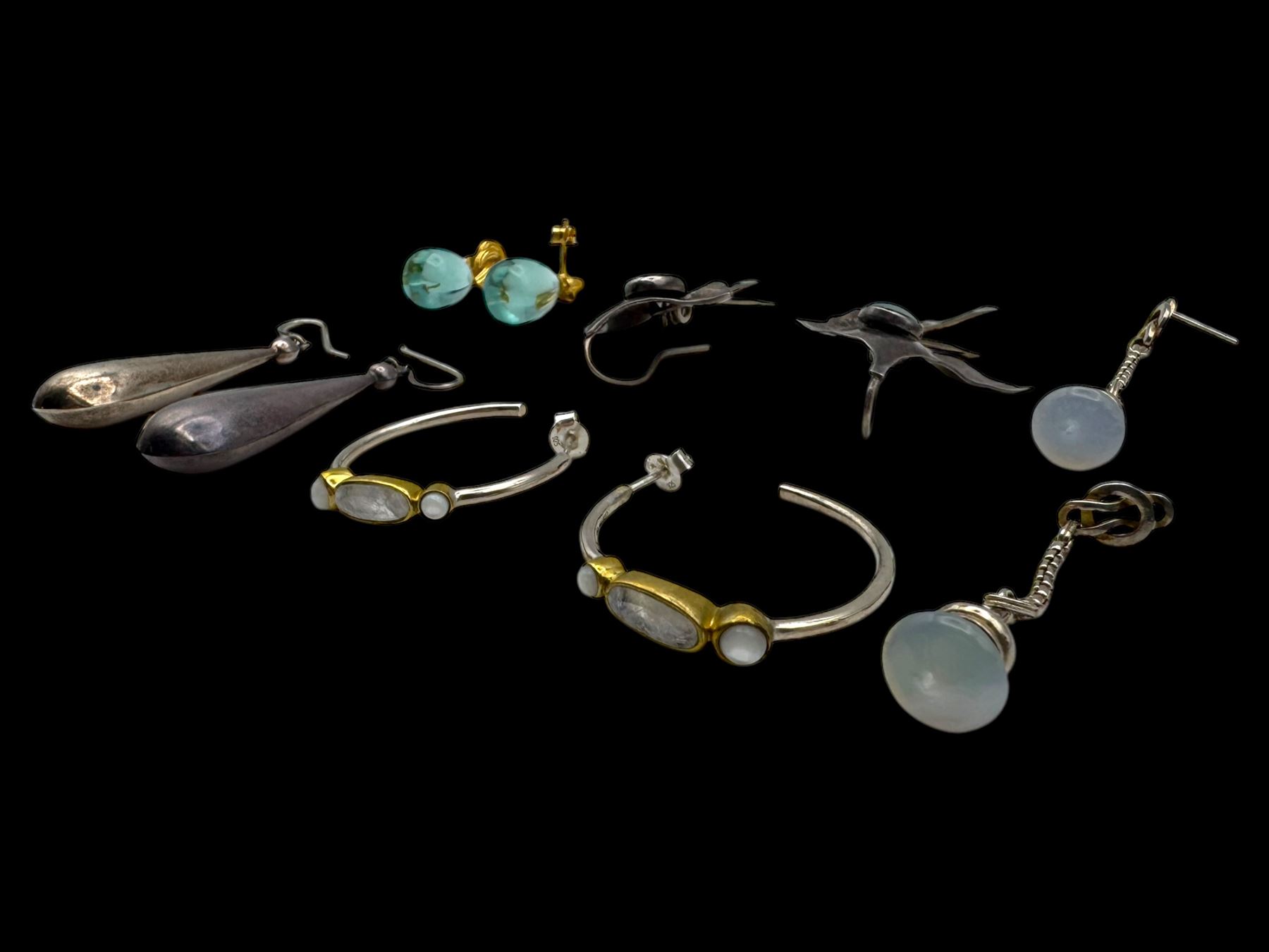 Six pairs of silver earrings, including opal pendant earrings and a pair of moonstone hoop earrings